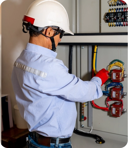 A licensed and uniformed electrician in Dubai inspecting a breaker box